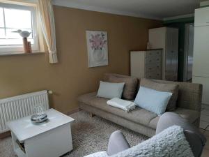 ein Wohnzimmer mit einem Sofa und einem Tisch in der Unterkunft Gästehaus Melz Schwabe in Scharbeutz
