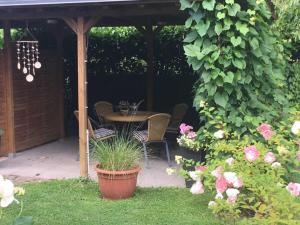 um pátio com uma mesa e cadeiras sob uma pérgola em Gästehaus Melz Schwabe em Scharbeutz