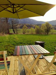 einen Picknicktisch mit Sonnenschirm und Feld in der Unterkunft Lika Sunset in Ličko Lešće