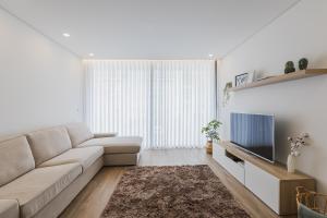a living room with a couch and a tv at Paim XXI Azores Apartment in Ponta Delgada