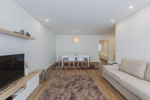 ポンタ・デルガダにあるPaim XXI Azores Apartmentのリビングルーム(ソファ、テーブル、椅子付)