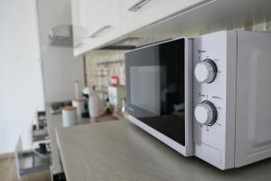 a microwave oven on a counter in a kitchen at Casa SavAnna in Torre Lapillo