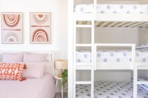 - une chambre avec des lits superposés et des lits superposés blancs dans l'établissement Sailfish Studio - Beachside Private Access Granny Flat by uHoliday, à Kingscliff