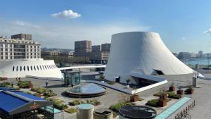 a view of a building with two white structures at L'Escale Appartements et Suites en bord de Mer in Le Havre