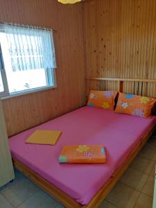 a bed in a wooden room with a purple mattress at Spitaki in Epanomi