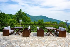 a patio with tables and chairs and mountains in the background at Manthos Mountain Resort & Spa in Chania