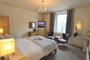 a hotel room with a bed and a bathroom at All Seasons Guest House in Windermere