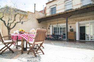 einen Tisch und Stühle mit einem roten und weißen Tischtuch in der Unterkunft Casa rural La Esencia de Don Quijote in Bolaños de Calatrava