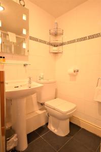 Un baño blanco con inodoro y lavabo. en All Seasons Guest House, en Windermere 18 fotos más