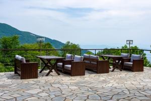 eine Terrasse mit einem Tisch, Stühlen und Bergen in der Unterkunft Manthos Mountain Resort & Spa in Chania