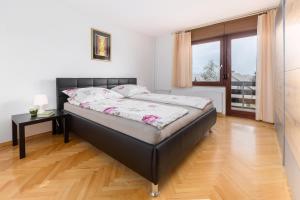 a large bed in a room with a wooden floor at Apartment Valy - big terrace & free bikes in Bled