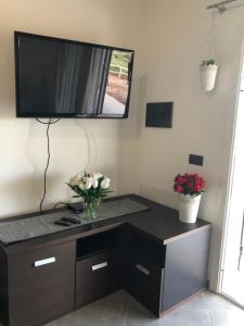 a living room with a tv on the wall at Villa Maralai in Orosei