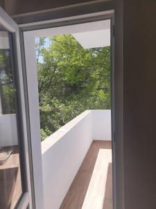 a glass door leading to a balcony with a tree at Sandanski city center apartment in Sandanski