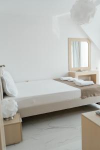 a white bedroom with a bed and a mirror at Dion Apartments in Lozenets