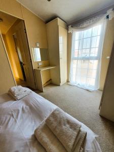 a bedroom with a bed with two towels on it at Lary Camping Homes - Domki Dabrowka in Gostynin