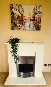 a fireplace in a room with a painting on the wall at Lary Camping Homes - Domki Dabrowka in Gostynin