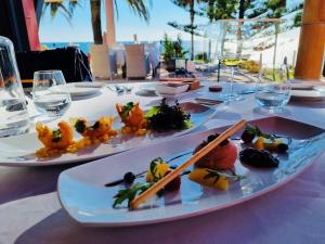 two plates of food on a table with wine glasses at Boutique Hotel Vivenda Miranda in Lagos