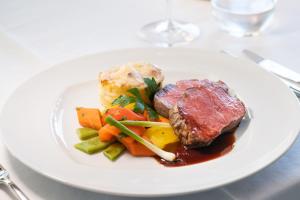 a plate of food with meat and vegetables on a table at Boutique Hotel Vivenda Miranda in Lagos