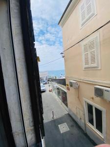 uitzicht op een straat vanuit een raam van een gebouw bij VISUM Apartments in Piran