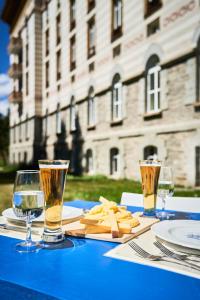 a blue table with two glasses of wine on it at Maloja Palace Suites CO2-Neutral in Maloja