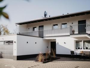 Biały dom z balkonem i patio w obiekcie Rheinzeit-Weisweil w mieście Weisweil