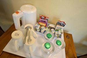 a table with a coffee maker and cups and toothbrushes at All Seasons Guest House in Windermere