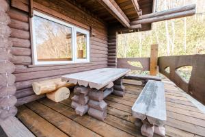 un banco de madera sentado en el porche de una cabaña de madera en Lake Toya Hillside House en Lake Toya