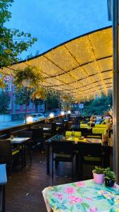 a restaurant patio with tables and chairs and lights at ZU DEN LINDEN - RADEBEUL Pension mit Restaurant in Radebeul