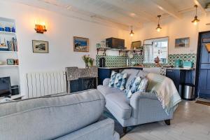 
a living room filled with furniture and a couch at Cosy Mousehole Cottage With Sea Views in Mousehole

