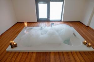 a bath tub filled with white foam on a wooden floor at Taksim 11 Suites in Istanbul