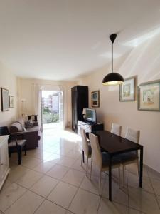 a dining room and living room with a table and chairs at Palace Britannique Love and magic in Bordighera in Bordighera