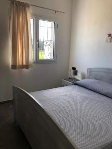 a bedroom with a bed and a window at Villa Maralai in Orosei