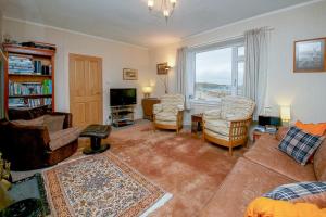 a living room with a couch and chairs and a television at 27 Garenin in Carloway