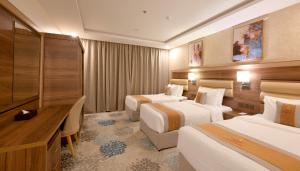 um quarto de hotel com duas camas e uma secretária em Azard Hotel em Medina