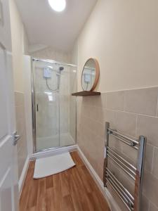 a bathroom with a shower and a mirror at Perfect Location 2 BR serviced apartment Nr Bike Park Wales & Brecon Beacons in Merthyr Tydfil