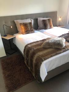 a bedroom with two beds with furry blankets on them at Logies Dampoort in Ghent