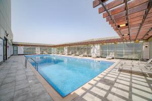 a large swimming pool with chairs on a building at Platinum Coast Hotel Apartments in Fujairah