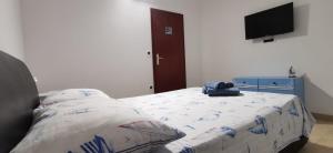 Cette chambre comprend un lit avec un oreiller et une télévision. dans l'établissement Apartments K&D, à Pula