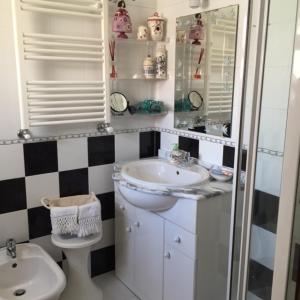 a bathroom with a sink and a toilet and a mirror at Casa da Gó in Ericeira