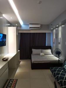 a bedroom with a bed and a tv in it at LIAM's Staycation in Manila