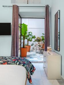 a bedroom with a bed and a balcony with plants at Art Suites by Casa de Indias in El Puerto de Santa María