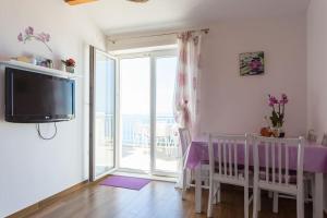 a room with a table and a tv and a balcony at Romantic Ap,with amazing view in Dubrovnik