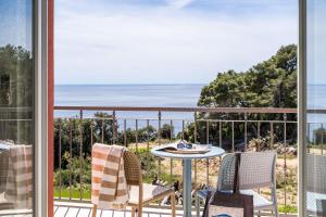 a balcony with a table and chairs and a view of the ocean at Apartments Villa Lukas in Cavtat