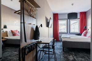 una camera d'albergo con 2 letti e una scrivania di Hotell Fridhemsgatan a Mora