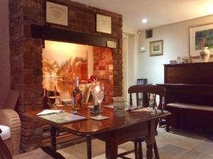 a table in a living room with a brick fireplace at Virginia Cottage in Bulwick