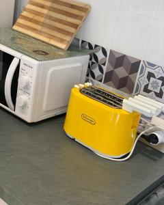 a yellow toaster on a counter next to a microwave at Dodo home beach in Lavagna