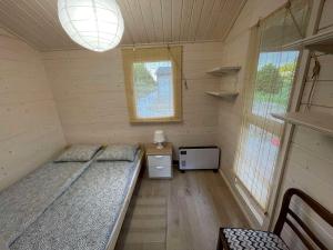 Habitación pequeña con 2 camas y ventana en Domki Letniskowe na Dzikiej en Tolkmicko