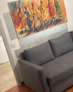 a living room with a couch and a painting on the wall at Dodo home beach in Lavagna