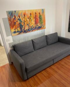 a couch in a living room with a painting on the wall at Dodo home beach in Lavagna