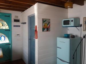 a room with a refrigerator and a microwave on a wall at Excelente Cabaña Cumbre del Diablo 1 in Punta Del Diablo